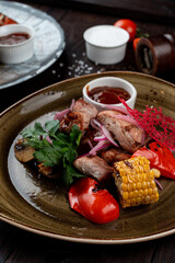 Pork shashlik without skewer with grilled vegetables: bell pepper, corn and red onion, mouthwatering close up shot