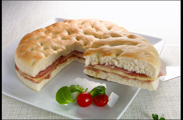 Sándwich redondo  de beicon con queso con tomates cherri. Round cheese bacon sandwich with cherry tomatoes.