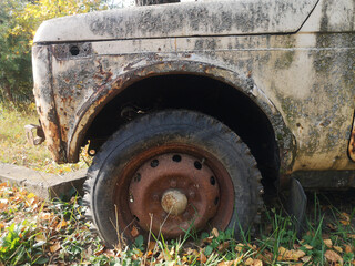 Fototapeta na wymiar Detail of the wheel of an old abandoned car outside