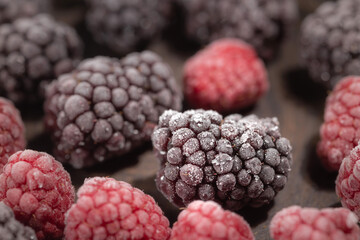 Frozen blackberries and raspberries, forest berries background, selective focus