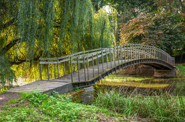 An old, wooden arch bridge in the dutch park in the south of The Netherlands