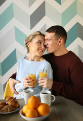 Lifestyle and people concept: Young happy lovely couple have breakfast in the early morning at home, hug, smile.