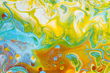 Abstract background from spilled paints. Multi-colored paints on canvas.