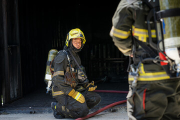 Fireman,Firefighters fighting a fire and spraying high pressure water to fire.