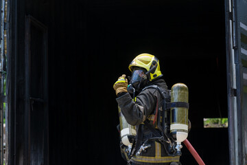 Fireman extinguishes a fire,Firefighter water spray by high pressure fire hose in an emergency...