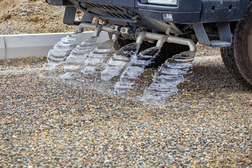 Water truck spraying new gravel road