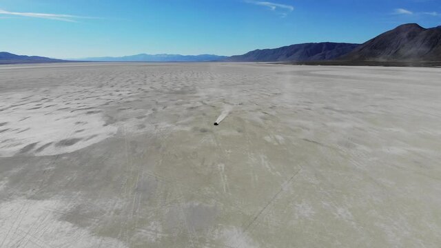 Drone view on sportcar with good tires for drifting and bashing in wild nature environment riding at beautiful landscape, Bonneville salt flats lake with extreme automobile driving
