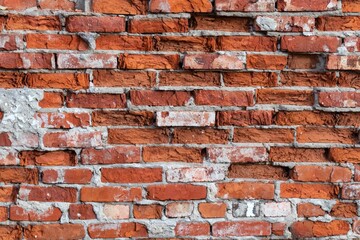 Background texture of an old brick wall with traces of plaster.
