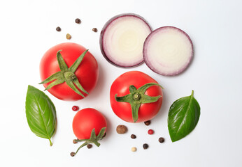 Fresh vegetables tomatoes, basil, onions and black pepper on a white background. The concept of delicious and healthy food, ingredients for cooking