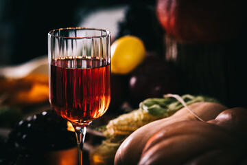 Glass of rose wine or cider in wine glass in a moody autumn vintage atmosphere