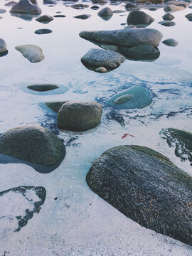 Vertical shot of big rocks on a frozen lake