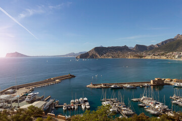 Obraz premium Coastline of the Mediterranean resort of Calpe, Spain with sea and yachts, lake, skyscrapers and mountain range.