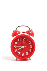 Red alarm clock isolated on a white background shows eight clock in morning.
