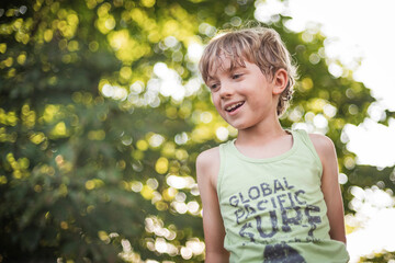 outdoor portrait of a cute nine years old boy with beautiful bokeh in the background