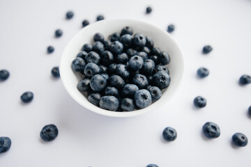 Beautiful ripe blueberries in a glass bowl on a white background. Healthy food, and vitamins.