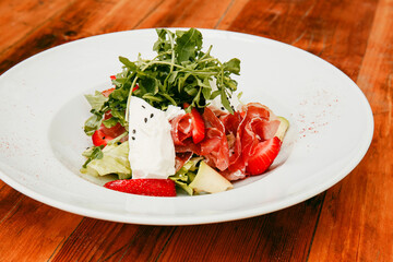 Summer salad with strawberries, arugula and cheese