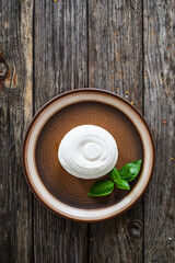 Fresh ricotta cheese and vegetables on wooden table
