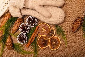 Beautiful christmas composition of cones, spruce branches and warm white mittens