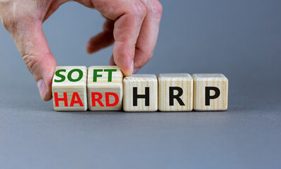 HRP, human resource planning symbol. Businessman turns wooden cubes and changes words hard HRP to soft HRP. Beautiful grey background. Business, HRP, human resource planning concept. Copy space.