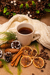 Obraz na płótnie Canvas Beautiful stylish christmas composition with a cup of tea, cinnamon and pine cones 