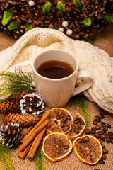 Obraz na płótnie Canvas Beautiful stylish christmas composition with a cup of tea, cinnamon and pine cones 