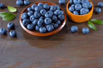 blueberries in wooden bowls close-up. background with fresh blueberries. blueberries close-up on a wooden background.