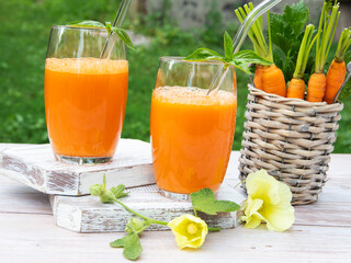 Fresh squeezed  carrot juice in a two glass. Healthy eating, detox, dieting and vegetarian concept. Outdoors