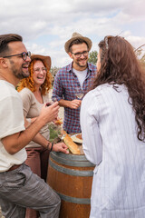 Happy friends having fun drinking wine at winery vineyard - Friendship concept with young people...