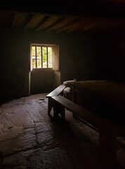 interior view of a lonely and twilight stone hut with illuminated window