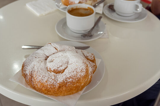 Ensaimada, typical Spanish sweet from the Balearic Islands, accompanied by a coffee in a restaurant.