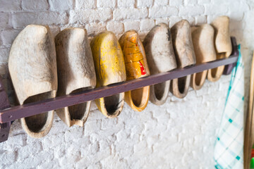 Rack of Dutch clogs on wall in selective focus.