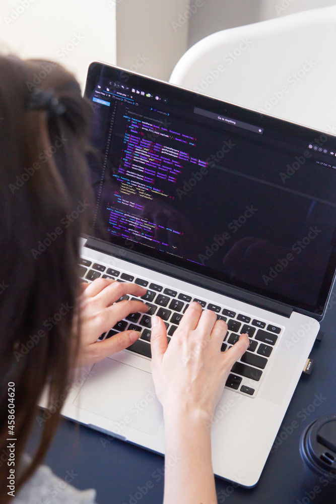 Wall mural A programmer coding on a laptop in the workplace