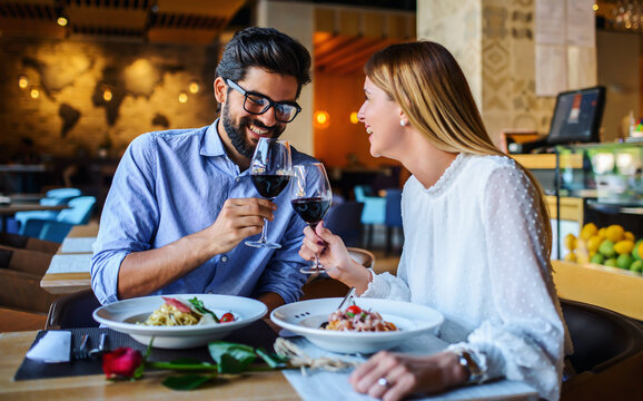 Red wine and paste. Happy couple enjoying lunch in the restaurant. Lifestyle, love, relationships, food concept