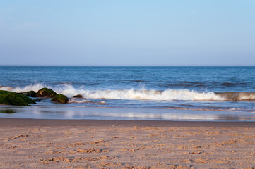 Fototapeta na wymiar Shoreline of beach with waves and sky. 
