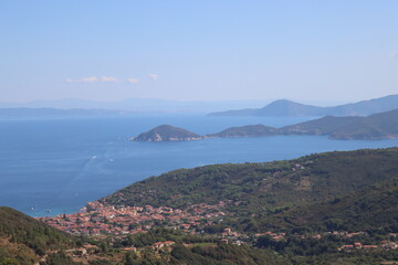 Fototapeta na wymiar Elba, Italy – September 01, 2021: beautiful places from Elba Island. Aerial view to the island. Little famous villages near the beaches. Summer tourist places. Clouds and blue sky in the background.