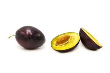 Ripe fresh organic plum whole and half isolated on white background.	