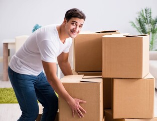 Young man moving boxes at home