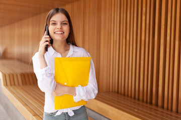 The girl with the yellow folder. An office worker carrying documents. A girl and her.coursework.