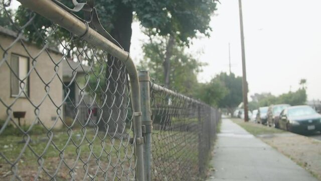 Urban City Neighborhood Chainlink Fence. Dolly Past Fence On Sidewalk. Los Angeles, True Crime Coverage
