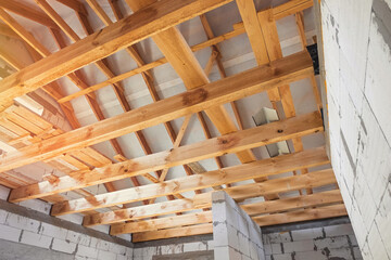 New construction of the house. Construction of a wooden roof from beams, interior view of the roof structure