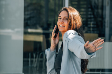 Fototapeta premium business woman talking on mobile phone in the street