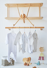 Scandinavian style white interior children's room, bedroom, nursery. Baby cot with ​canopy. Wooden shelves and toys. Wooden shelf in form of an airplane