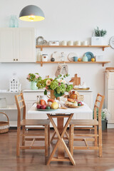 Autumn postcard. Thanksgiving Day. Halloween. White kitchen with pumpkins and flowers. Harvest background