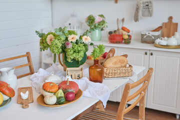 Autumn postcard. Thanksgiving Day. Halloween. White kitchen with pumpkins and flowers. Harvest background