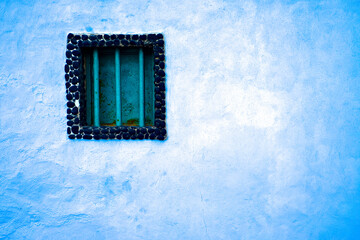 Barred window,  a window resembling a prison cell window, light blue, almost white empty wall.