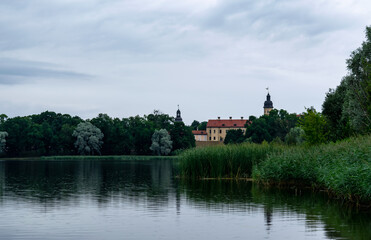 Fototapeta na wymiar Lake overlooking the ancient castle of the Radziwills Nesvizh, Belarus. Beautiful summer landscape with architectural elements.