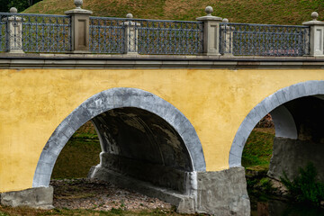 Fototapeta na wymiar An ancient arched bridge over the moat to the castle. Architectural elements.