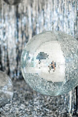 A mirror ball in a room decorated with silver decor. 