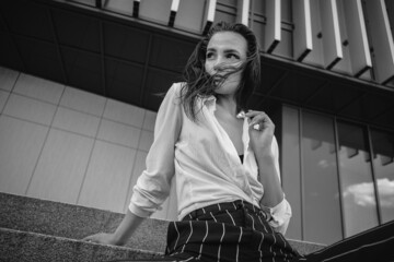 A melancholic black and white portrait of a young girl. A brunette in a white shirt and striped...