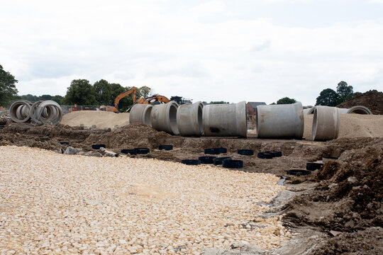 Big diameter concrete drainage pipe on new housing and road development site ready to be installed  to form drainage system and attenuation tank to store excess of storm rain water  